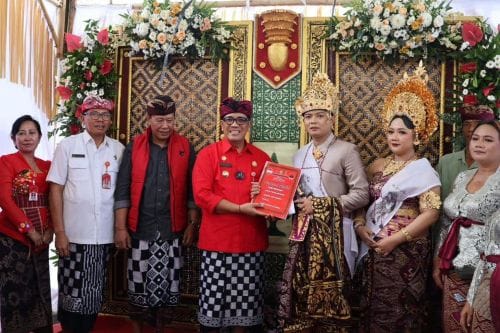 Bupati Sanjaya menyerahkan berkas data kependudukan kepada kedua mempelai bagian dari program Semararatih