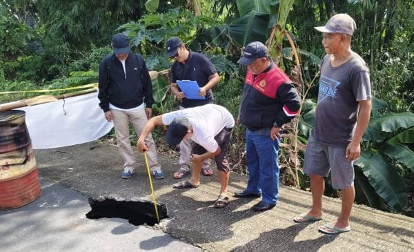 Petugas dari Dinas PU mengecek jalan jebol di Desa Tista, Kerambitan, Tabanan