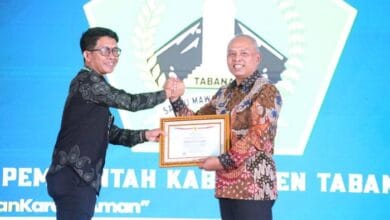 Kepala Dinas Komunikasi dan Informatika Kabupaten Tabanan diwakili oleh Kepala Bidang Teknologi Informasi dan Komunikasi (TIK), I Made Adi Wibawa (kiri) menerima Surat Tanda Registrasi (STR) TTIS dari BSSN