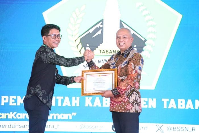 Kepala Dinas Komunikasi dan Informatika Kabupaten Tabanan diwakili oleh Kepala Bidang Teknologi Informasi dan Komunikasi (TIK), I Made Adi Wibawa (kiri) menerima Surat Tanda Registrasi (STR) TTIS dari BSSN