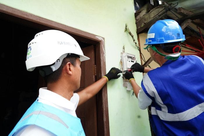 Ilustrasi petugas memasang kWh pada pelanggan