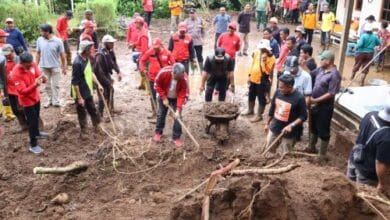 Wabup Made Pemkab TabananDirga ikut gotong royong membersihkan tanah di halkaman rumah warga di Pujungan, Pupuan