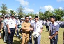 Bupati Adi Arnawa menyerahkan bantuan helm kepada perwakilan siswa-siswi SMA Negeri 2 Abiansemal serangkaian Peringatan Hari Perhubungan Nasional Ke-55 Tahun 2026 tingkat Kabupaten Badung