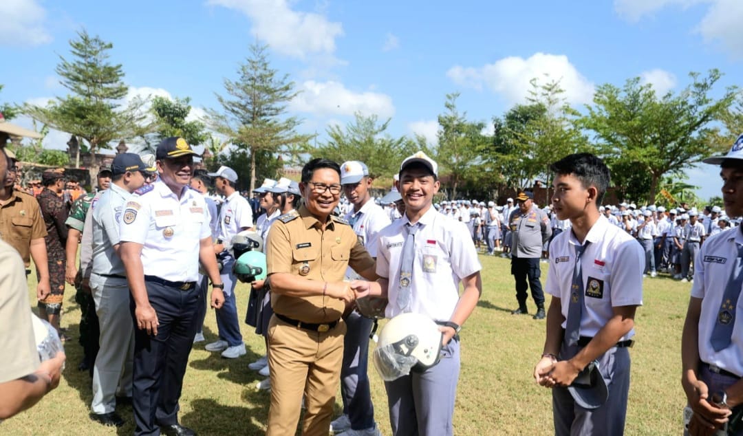 Bupati Adi Arnawa menyerahkan bantuan helm kepada perwakilan siswa-siswi SMA Negeri 2 Abiansemal serangkaian Peringatan Hari Perhubungan Nasional Ke-55 Tahun 2026 tingkat Kabupaten Badung
